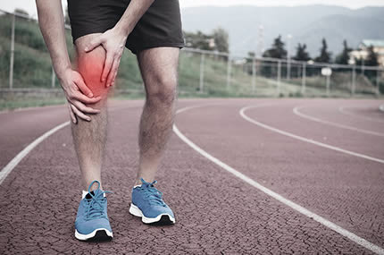 Mann greift sich ans Knie, das rot als Schmerzstelle markiert ist