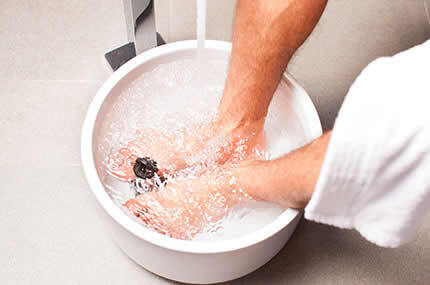 Füße baden in einem Fußbad, um Hornhaut, Hühneraugen und Fußprobleme zu behandeln