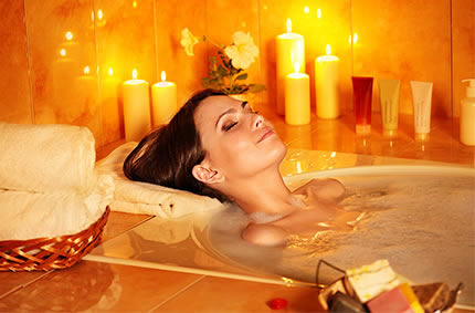 rau entspannt in der Badewanne, umgeben von Kerzenlicht
